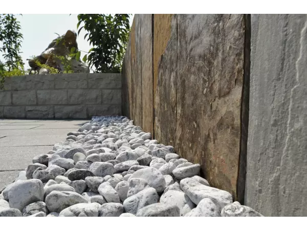 Palisada z płyt łupkowych łącząca donice w architekturze tarasu